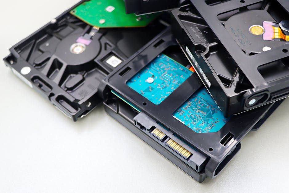 Stack of Hard Disk Drives with Exposed Chips on White Surface